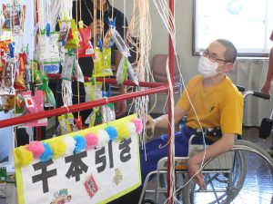 車椅子利用者が参加するレクリエーション活動。壁面に装飾や作品が展示されている様子。